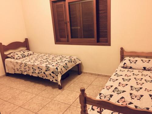 a bedroom with two beds and a window at Apartamento amplo 300m da praia in São Lourenço do Sul