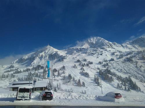 a snow covered mountain with cars parked in the snow at Party Hotel Taverne in Obertauern