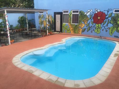 een zwembad voor een gebouw met een muurschildering bij Bob Apartments in Calodyne