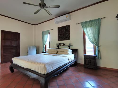 1 dormitorio con 1 cama y ventilador de techo en Tuna Resort, en Rawai Beach