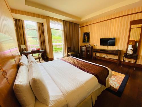 una camera d'albergo con un grande letto e una TV di PULSE GRANDE Hotel Putrajaya a Putrajaya