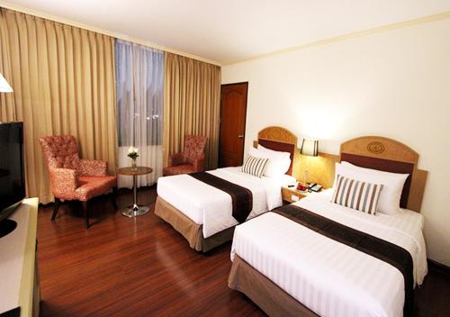 a hotel room with two beds and a television at Grand Tower Inn Rama 6 - SHA Extra Plus in Bangkok