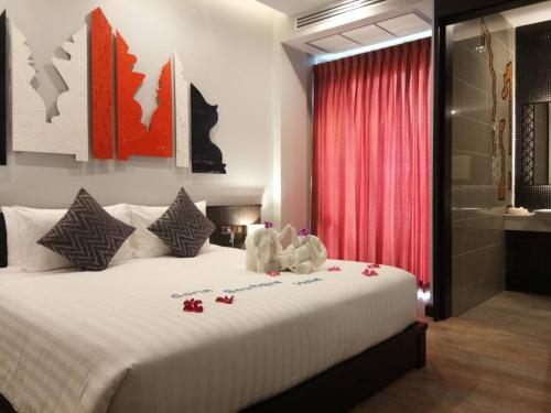 スリンにあるSorin hotelのベッドルーム(赤いカーテン付きの白い大型ベッド1台付)