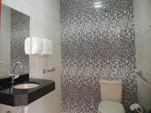 a bathroom with a toilet and a sink at Planeta Hotel in Colinas Do Sul