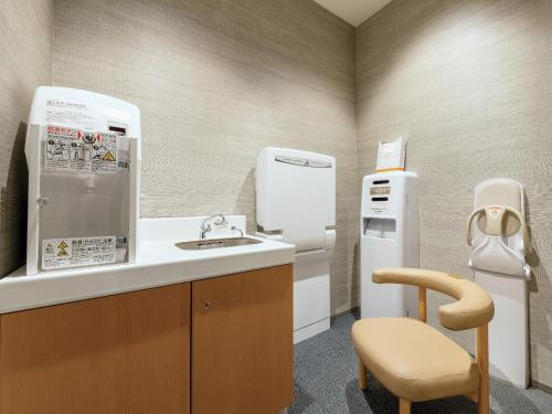 a kitchen with a sink and a refrigerator at Hotel Hankyu RESPIRE OSAKA in Osaka