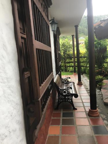 two benches sitting on the porch of a house at Casa Hotel Portón Campestre in Jardin