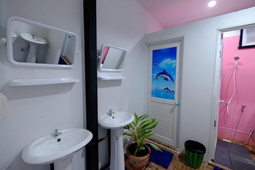 ein Bad mit 2 Waschbecken und einem TV an der Wand in der Unterkunft Sangchan hostel in Ko Lipe