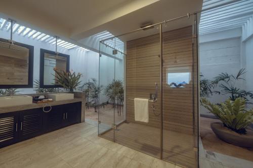 a bathroom with a shower with a glass door at The Beach House by Reveal in Mirissa