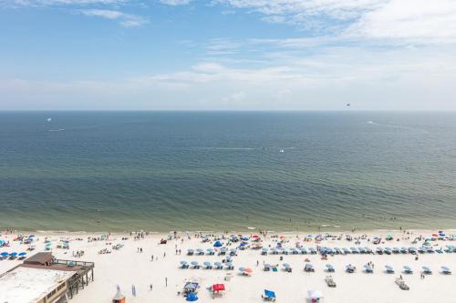 un grupo de personas en una playa con el océano en Seawind Condominiums en Gulf Shores