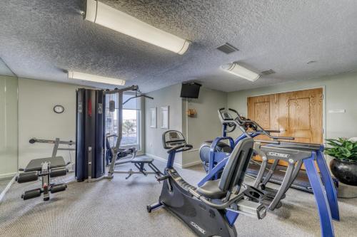 una sala de fitness con cintas de correr y equipos de ejercicio en The Colonnades en Gulf Shores