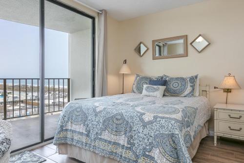 a bedroom with a bed and a balcony at Gulf Village #215 in Gulf Shores