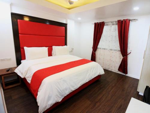 a bedroom with a large bed with a red headboard at Manarra Sea View Resort in Puerto Galera