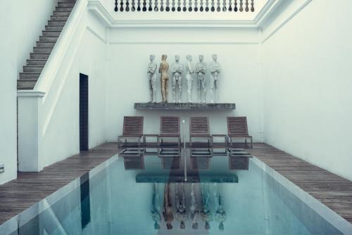 a pool with a group of statues in a building at Paradise Road Tintagel Colombo in Colombo