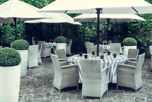a group of tables with white chairs and umbrellas at Paradise Road Tintagel Colombo in Colombo