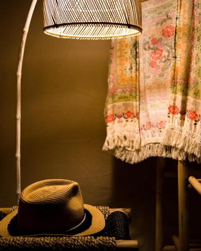 a hat sitting on a table next to a lamp at Autentik Penida "Glamping" - Adults only in Nusa Penida