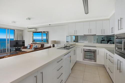 a kitchen with white cabinets and a view of the ocean at Points North Apartments in Gold Coast