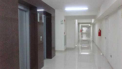 an empty hallway in a hospital with a fire extinguisher at Apartamento completo en centro historico in Lima