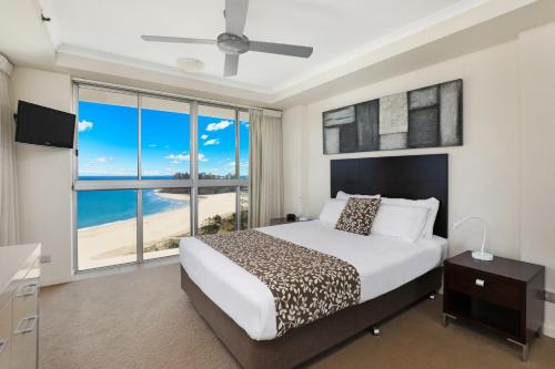 a bedroom with a bed with a view of the beach at Points North Apartments in Gold Coast