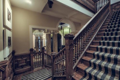 a staircase in a home with wooden railings at Paradise Road Tintagel Colombo in Colombo
