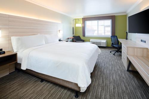 a hotel room with a large bed and a desk at Holiday Inn Express Hotel & Suites Watsonville, an IHG Hotel in Watsonville