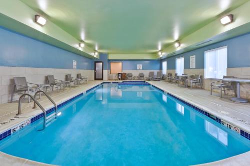 a pool with chairs and tables in a hotel room at Holiday Inn Express Hotel & Suites Cleveland-Richfield by IHG in Brecksville