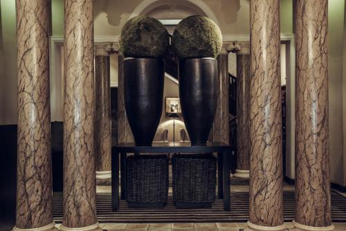 a group of vases on a table with columns at Paradise Road Tintagel Colombo in Colombo