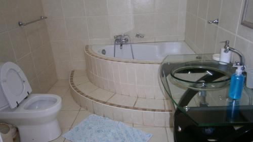 Un baño con bañera, inodoro y lavabo. en Vila Sol - Self Catering, en Vila Praia Do Bilene