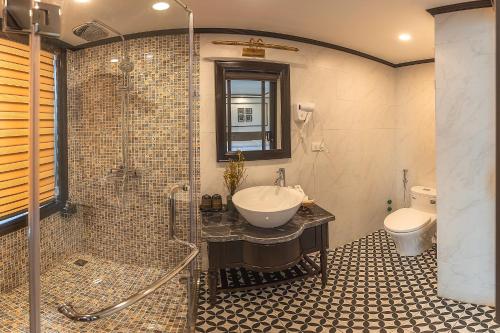 a bathroom with a sink and a shower and a toilet at Sena Cruises - Wonder On Lan Ha Bay in Ha Long