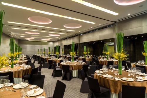 a banquet hall with tables and chairs in a room at Holiday Inn Bangkok Sukhumvit by IHG in Bangkok