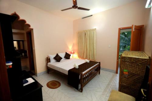 - une chambre avec un grand lit et une fenêtre dans l'établissement Ideal Ayurvedic Resort Kovalam, à Kovalam