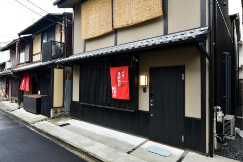a building with a red sign on it on a street at Miro Hachijo Genmachi BeTei in Kyoto