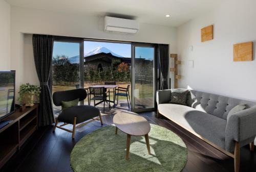 a living room with a couch and a table at Kawaguchiko Urban Resort Villa in Fujikawaguchiko