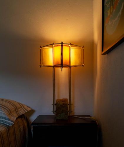 a lamp sitting on a table next to a bed at Casa El Cedro in Charalá
