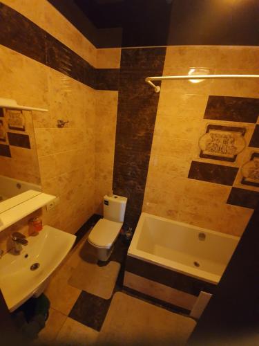 ein Badezimmer mit einem WC, einem Waschbecken und einer Badewanne in der Unterkunft Порт Сіті in Luzk