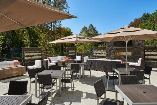 a patio with tables and chairs and umbrellas at Holiday Inn & Suites Philadelphia W - Drexel Hill by IHG in Drexel Hill