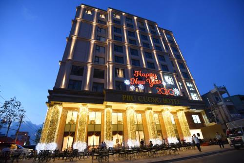 Um edifício com luzes de Natal à frente. em Phu Cuong Hotel Ca Mau em Cà Mau