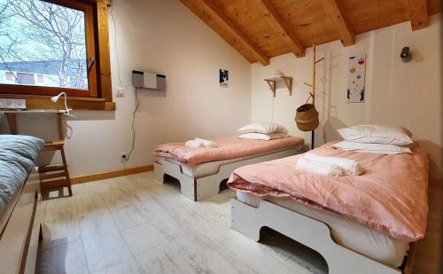 een slaapkamer met 2 bedden en een raam bij Le camp de base in Chamonix-Mont-Blanc