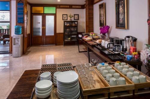a kitchen with a table with plates and cups on it at Lee Chiang Hotel in Chiang Mai