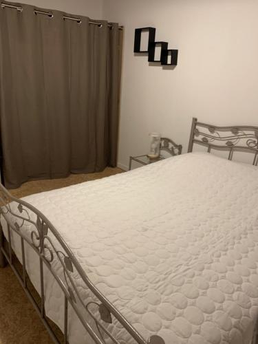 een bed in een slaapkamer met een witte matras bij La Caminada in Fougax-et-Barrineuf