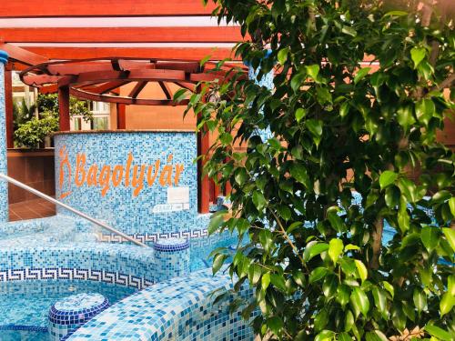 a swimming pool with a sign on the side of a building at Bagolyvár Inárcs in Inárcs