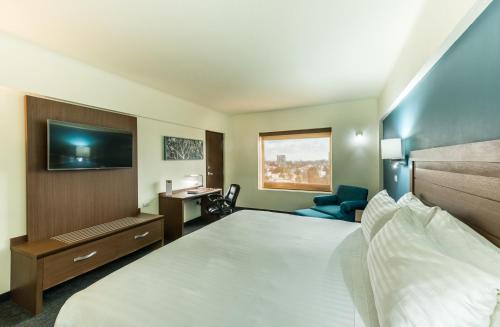 Ένα ή περισσότερα κρεβάτια σε δωμάτιο στο Holiday Inn Guadalajara Expo Plaza del Sol by IHG