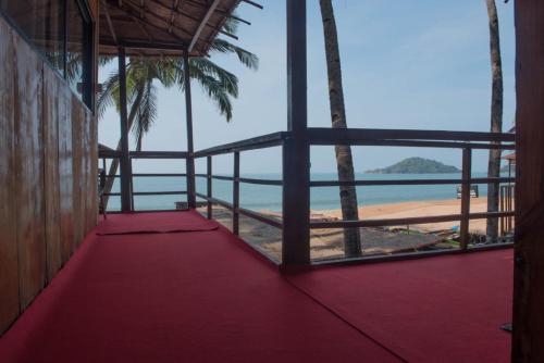 a view of the beach from a room with a red floor at Magic World in Palolem