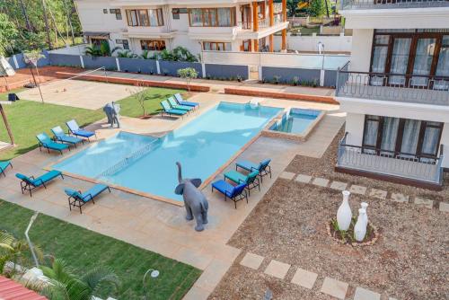 una vista aérea de una piscina con sillas y una estatua de elefante en Villa Calangute Phase 17 -16 or 17BHK -Great For Large Groups, en Calangute