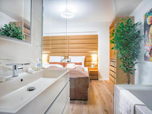 a bedroom with a bed and a sink and a tub at SKY9 Apartments City Center in Vienna