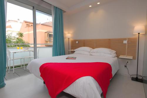 プエルト・デ・ラ・クルスにあるIriarte 52 Apartmentsのベッドルーム1室(赤い毛布付きの大型ベッド1台付)