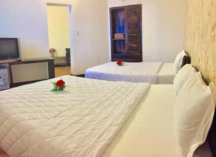 two beds in a hotel room with roses on them at KHÁCH SẠN HƯƠNG SEN PHÚ YÊN in Tuy Hoa