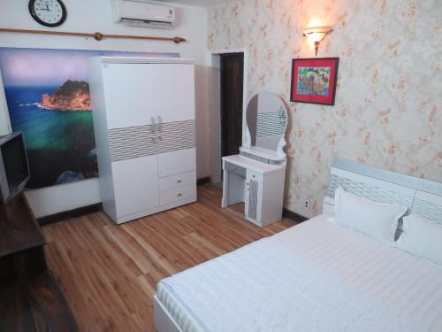 a bedroom with a bed and a chair and a mirror at KHÁCH SẠN HƯƠNG SEN PHÚ YÊN in Tuy Hoa