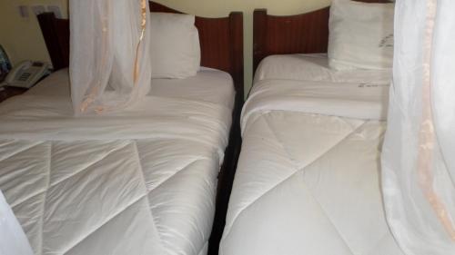 Кровать или кровати в номере Vienna Woods Hotel Nakuru