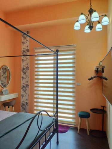 a bedroom with orange walls and a bed and a window at Teacher Cai Homeestay in Xiaoliuqiu