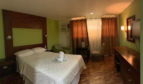 a hotel room with two beds and a television at Maharajah Hotel in Angeles